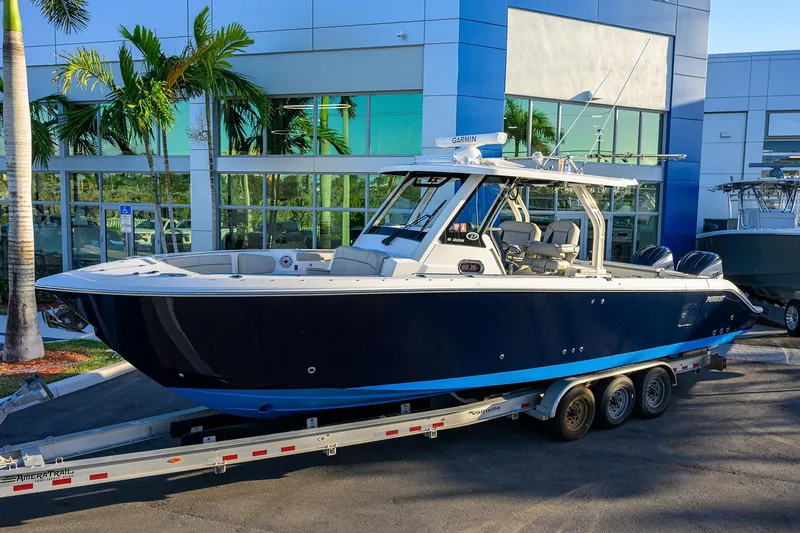 Slide: The Image of 2023 Pursuit S 328 Sport boat on trailer, parked outside modern building. - 2