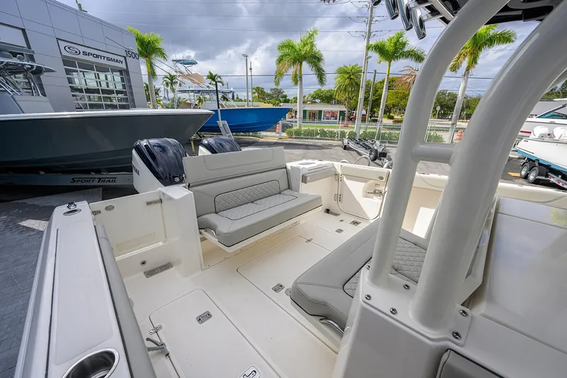 Slide: The Image of 2023 Pursuit S 328 Sport boat interior with seating, parked at a dealership. - 44