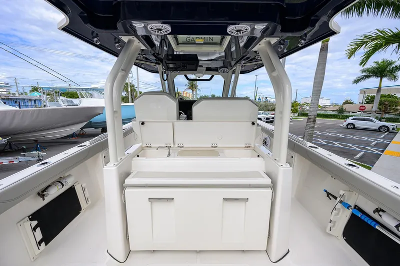 Slide: The Image of 2023 Pursuit S 328 Sport boat interior with seating and storage, docked outdoors. - 52