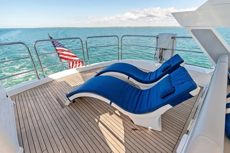 Slide: The Image of Sunseeker 76 Yacht 2019 deck with blue loungers and ocean view. - 53
