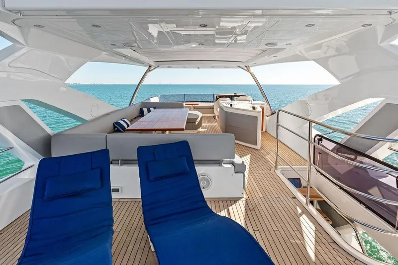 Slide: The Image of Luxurious 2019 Sunseeker 76 Yacht deck with seating, ocean view, and blue lounge chairs. - 55