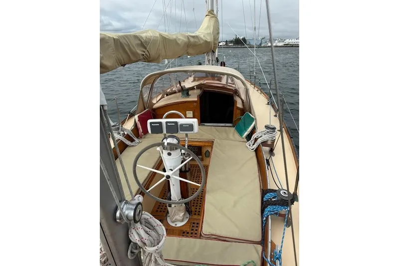 Slide: The Image of 1962 Ted Hood Little Harbor 40 Yawl sailboat cockpit with wheel and ropes on water. - 32