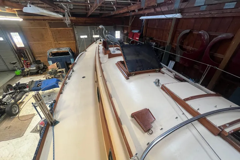 Slide: The Image of 1962 Ted Hood Little Harbor 40 Yawl in a wooden garage, showcasing deck details. - 44