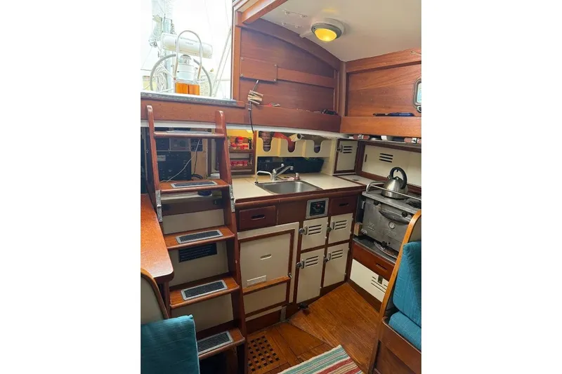 Slide: The Image of Interior of 1962 Ted Hood Little Harbor 40 Yawl, featuring a compact kitchen area. - 5