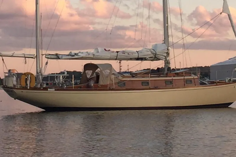 Slide: The Image of Classic 1962 Little Harbor Ted Hood 40 K/CB Yawl sailboat at sunset on calm water. - 50