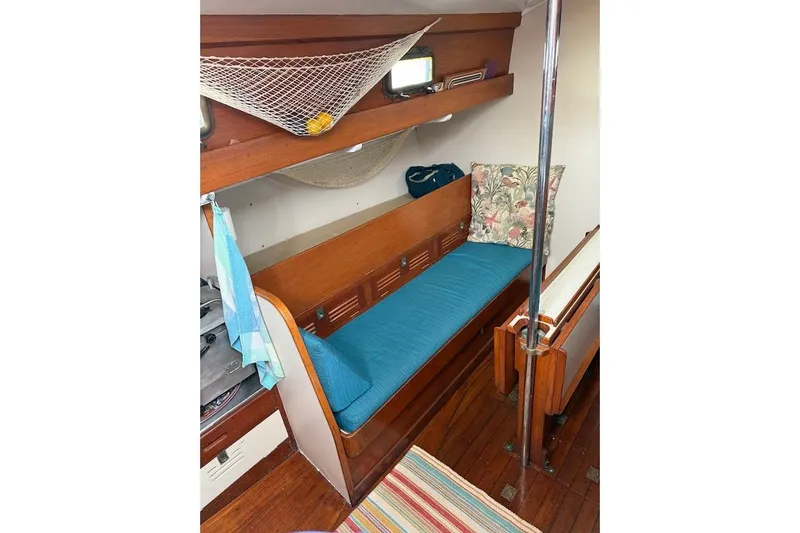 Slide: The Image of Interior of 1962 Ted Hood Little Harbor 40 Yawl with blue cushioned seating and wooden accents. - 7