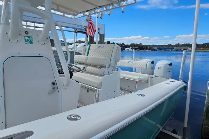 Slide: The Image of 2002 Yellowfin 31 Center Console boat docked by a serene waterfront. - 11