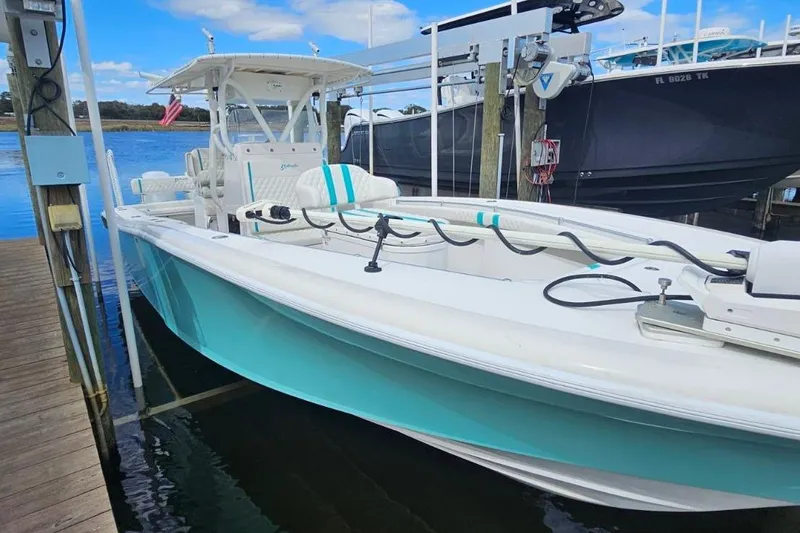Slide: The Image of 2002 Yellowfin 31 Center Console boat docked, featuring a sleek turquoise and white design. - 14