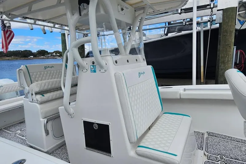 Slide: The Image of 2002 Yellowfin 31 Center Console boat interior with cushioned seating and American flag. - 18