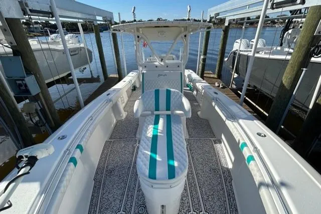 Slide: The Image of 2002 Yellowfin 31 Center Console boat with teal accents docked by the water. - 21