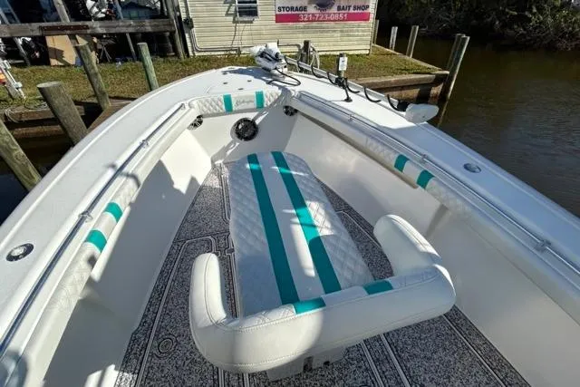 Slide: The Image of 2002 Yellowfin 31 Center Console boat with teal accents docked near a bait shop. - 23