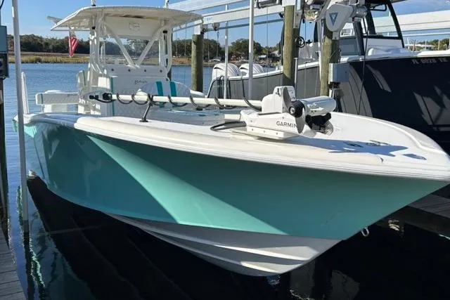 Slide: The Image of 2002 Yellowfin 31 Center Console boat docked, featuring a Garmin system and turquoise hull. - 25