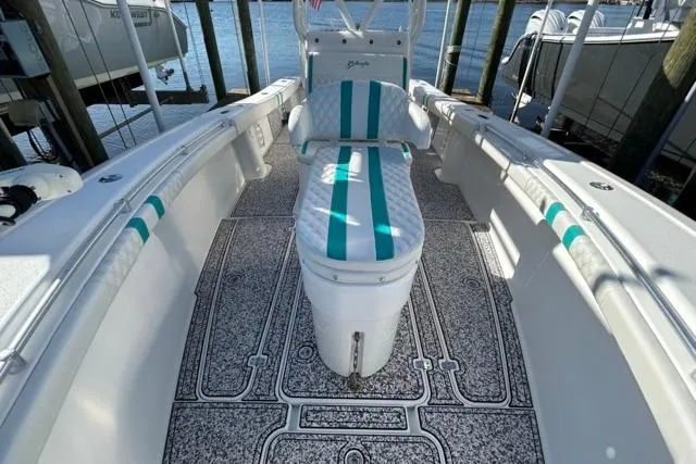 Slide: The Image of 2002 Yellowfin 31 Center Console boat with teal-striped seating and textured flooring. - 28