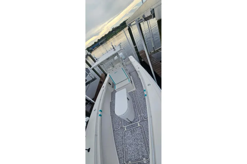 Slide: The Image of 2002 Yellowfin 31 Center Console boat docked by the water at sunset. - 3