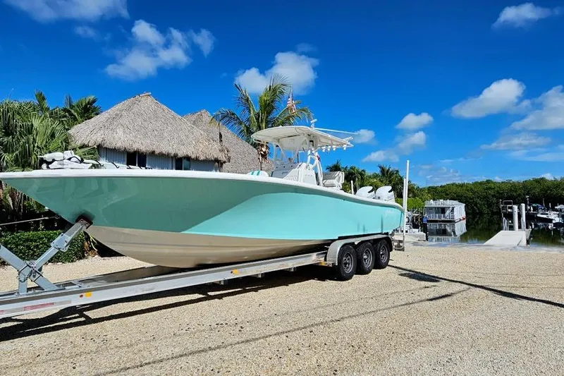 Slide: The Image of 2002 Yellowfin 31 Center Console boat on trailer, tropical setting, clear blue sky. - 5