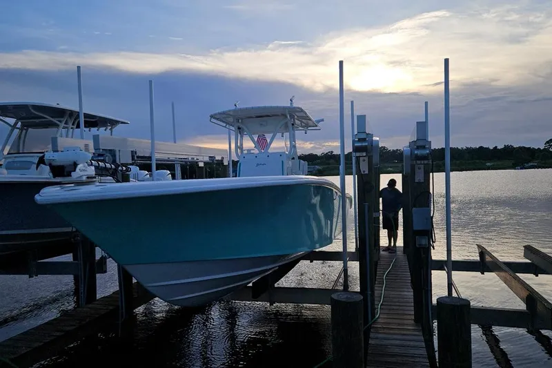 Slide: The Image of 2002 Yellowfin 31 Center Console boat docked at sunset, calm waters. - 7