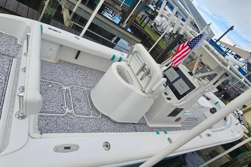 Slide: The Image of 2002 Yellowfin 31 Center Console boat docked, featuring spacious deck and American flag. - 8