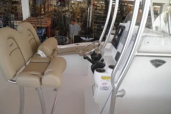 Slide: The Image of 2015 Tidewater 232 LXF boat interior with beige seating and control panel. - 17