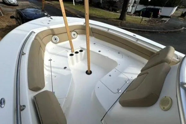 Slide: The Image of 2015 Tidewater 232 LXF boat interior with beige seating and cup holders. - 23