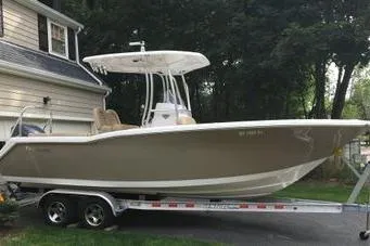 Slide: The Image of 2015 Tidewater 232 LXF boat on trailer, parked beside a house. - 5