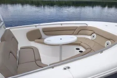 Slide: The Image of 2015 Tidewater 232 LXF boat with cushioned seating and table on calm water. - 8