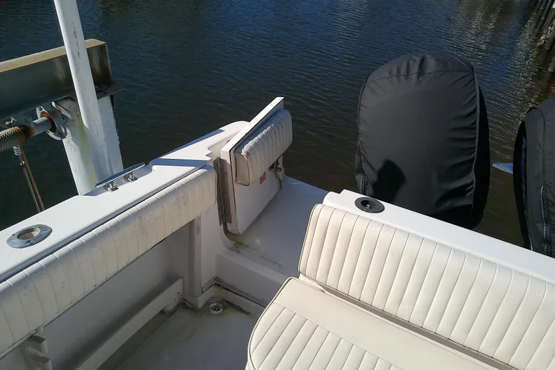 Slide: The Image of 1995 Grady-White Sailfish 272 boat interior with cushioned seating and covered engines. - 10