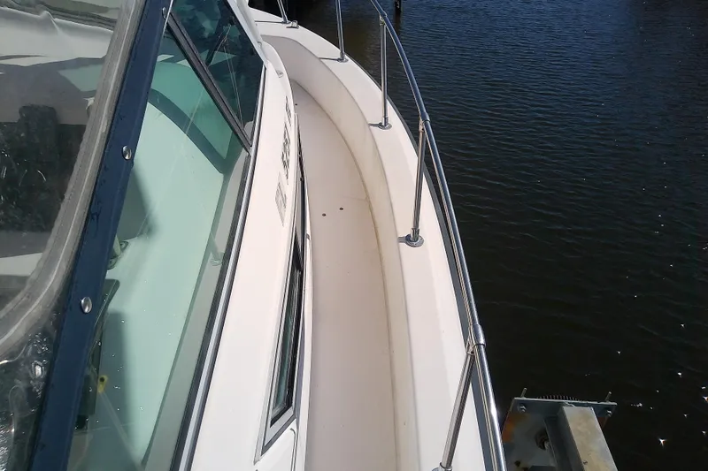 Slide: The Image of 1995 Grady-White Sailfish 272 boat deck with railing, docked on calm water. - 13