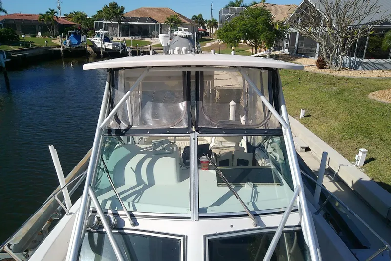 Slide: The Image of 1995 Grady-White Sailfish 272 boat docked in a scenic canal setting. - 14