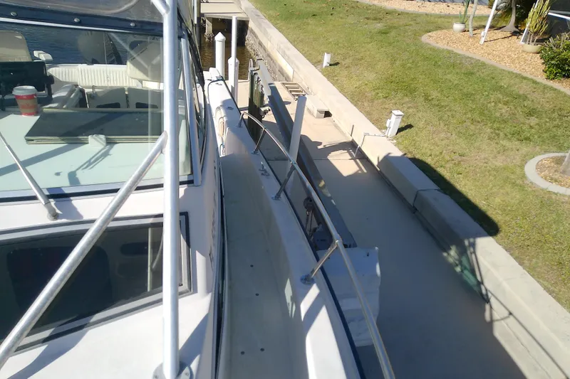 Slide: The Image of 1995 Grady-White Sailfish 272 docked, showing deck and railing details. - 17