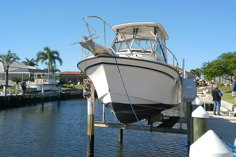 Slide: The Image of 1995 Grady-White Sailfish 272 boat on lift by waterfront homes. - 3