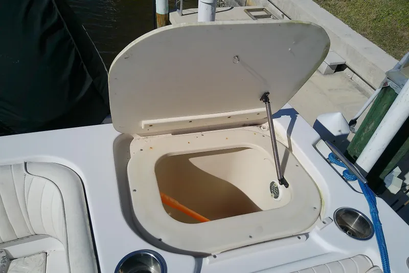 Slide: The Image of Open storage compartment on 1995 Grady-White Sailfish 272 boat, docked with blue rope. - 37
