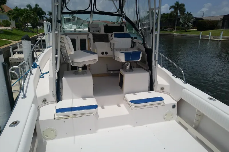 Slide: The Image of 1995 Grady-White Sailfish 272 boat interior with seating and steering console by the water. - 42