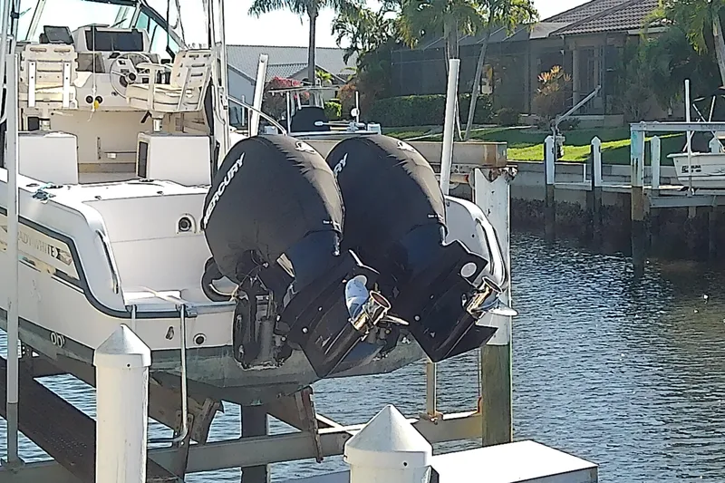 Slide: The Image of 1995 Grady-White Sailfish 272 with dual Mercury outboard motors docked by waterfront homes. - 5