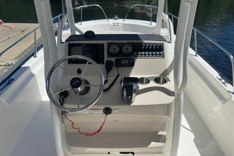 Slide: The Image of 2022 Boston Whaler 210 Montauk boat console with steering wheel and controls. - 10