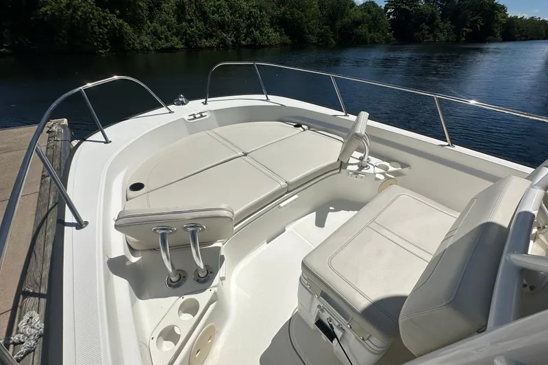 Slide: The Image of 2022 Boston Whaler 210 Montauk boat interior with cushioned seating by the water. - 15