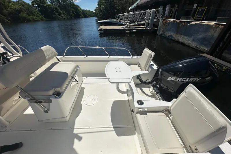 Slide: The Image of 2022 Boston Whaler 210 Montauk boat interior with Mercury engine, docked by a scenic river. - 4