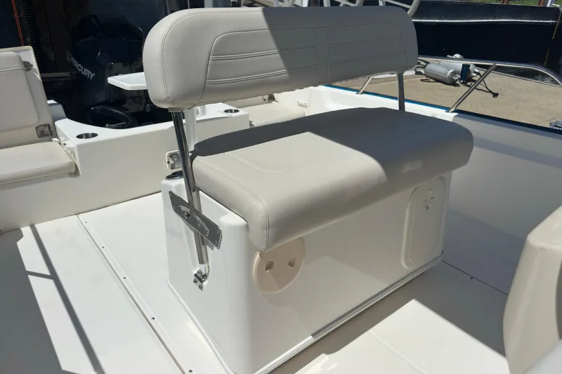 Slide: The Image of 2022 Boston Whaler 210 Montauk boat interior with cushioned seating and storage. - 9