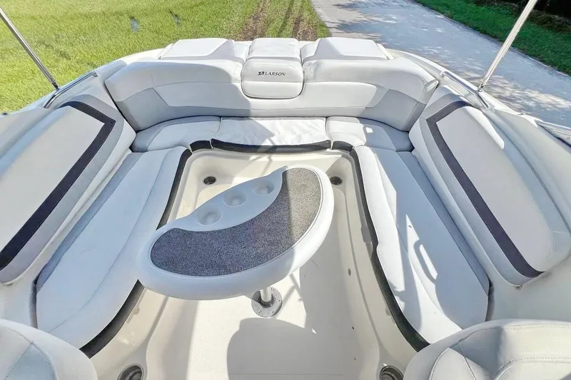 Slide: The Image of 2013 Larson LXi 292 IO boat interior with cushioned seating and table. - 10