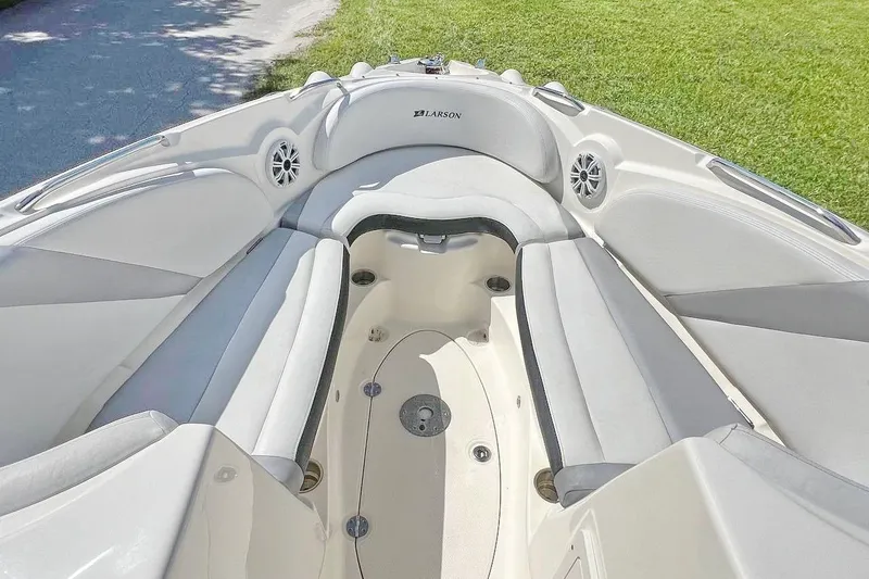 Slide: The Image of 2013 Larson LXi 292 IO boat interior with cushioned seating and speakers. - 12