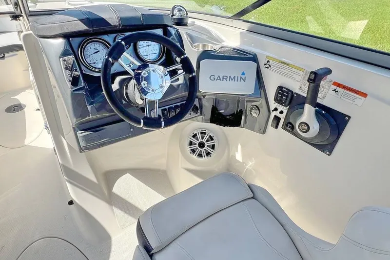 Slide: The Image of 2013 Larson LXi 292 IO boat dashboard with Garmin navigation system and steering wheel. - 16
