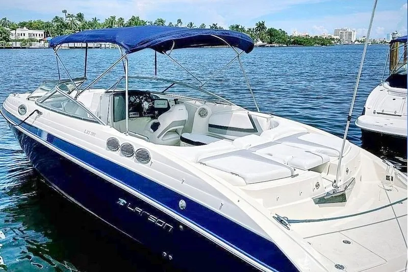 Slide: The Image of 2013 Larson LXi 292 IO boat with blue canopy on a sunny lake. - 20