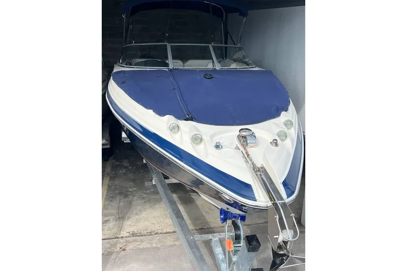 Slide: The Image of 2013 Larson LXi 292 IO boat with blue cover on trailer in storage. - 21