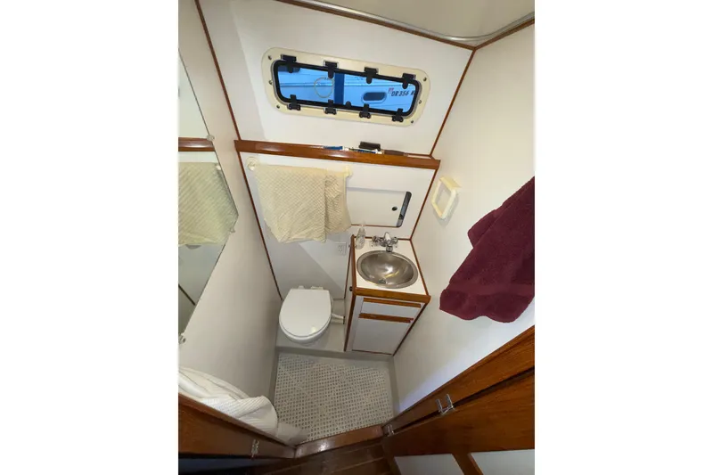 Slide: The Image of Compact bathroom in a 1997 Norstar 301 boat with sink, toilet, and porthole. - 14