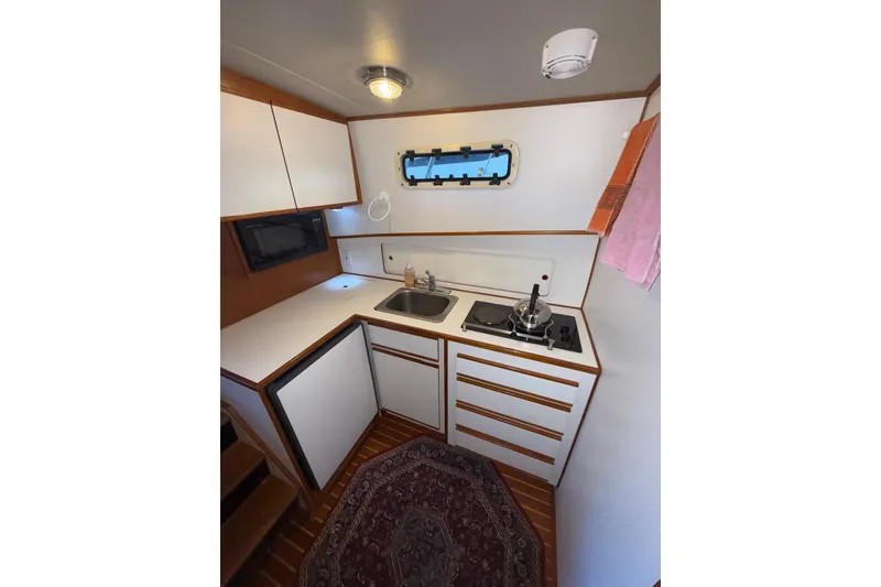 Slide: The Image of Compact kitchen in a 1997 Norstar 301 boat with stove, sink, and storage. - 17
