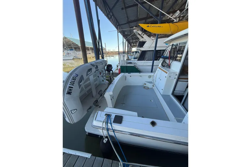 Slide: The Image of 1997 Norstar 301 boat docked with inflatable dinghy and kayak, under covered marina. - 2