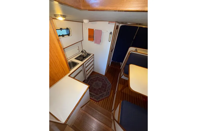 Slide: The Image of Interior of 1997 Norstar 301 boat featuring compact kitchen and dining area. - 21