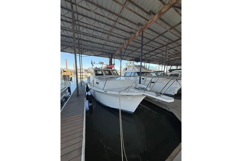 Slide: The Image of 1997 Norstar 301 boat docked in a covered marina. - 34