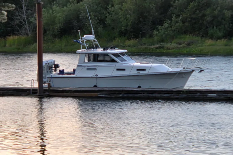 Slide: The Image of 1997 Norstar 301 boat docked on a calm river with lush greenery. - 35