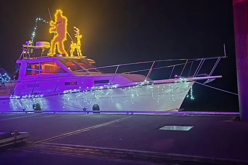 Slide: The Image of 1997 Norstar 301 boat adorned with festive lights and holiday decorations at night. - 37