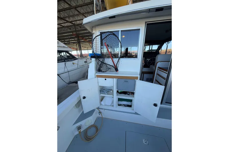 Slide: The Image of 1997 Norstar 301 boat interior with open storage compartments and fishing net. - 7